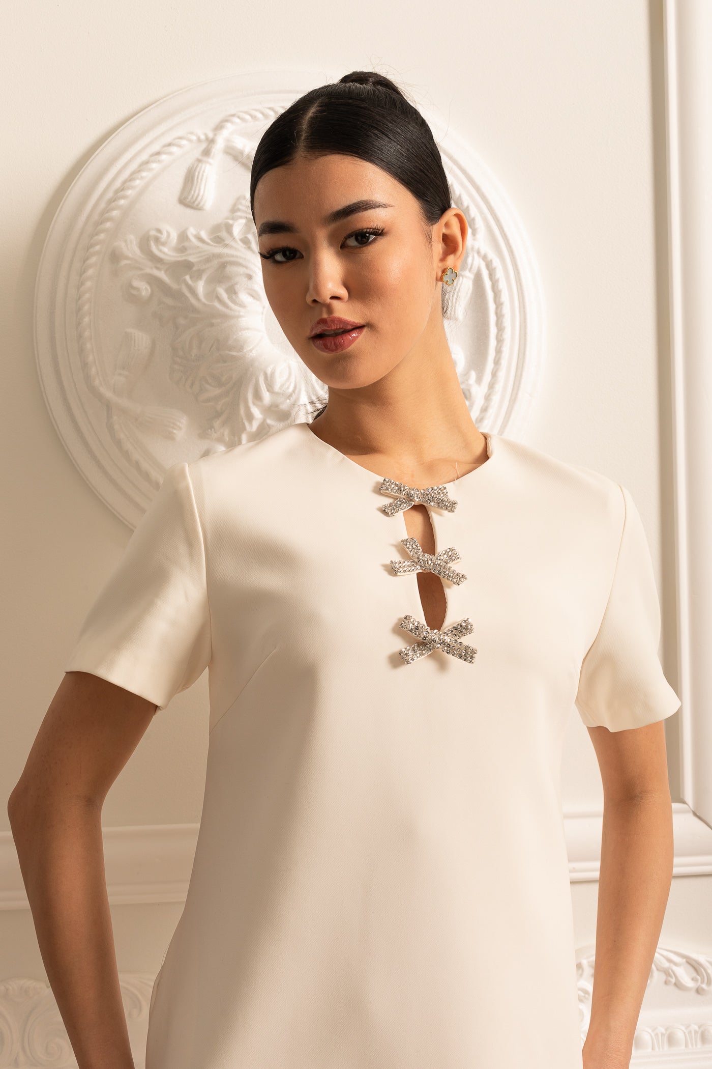 فستان ميني بأكمام قصيرة باللون الأبيض مع ياقة مزينة بأقواس متلألئة